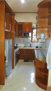 a kitchen with wooden cabinets and a refrigerator at Sari Inn Kuta Lombok in Kuta Lombok