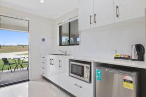 
a kitchen with a refrigerator, microwave, and dishwasher at Casa Nostra Motel in Rockhampton
