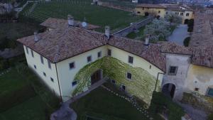 una vista aérea de una gran casa con hiedra en Relais Palazzo Lodron, en Rovereto