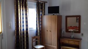 a room with a cabinet and a mirror and a window at Kabanis Rooms in Ermoupoli