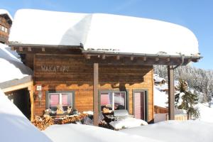 ein Blockhaus im Schnee mit Schnee in der Unterkunft Wakatipu-Lodge in Bettmeralp