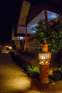 a lit up fire hydrant in front of a building at night at El Greco Bungalows Koh Lanta in Ko Lanta