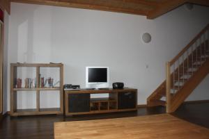 sala de estar con TV en un stand y una escalera en Wakatipu-Lodge, en Bettmeralp
