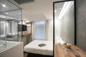 una camera da letto con un letto e una parete di vetro di Hotel Hart a Hong Kong