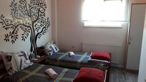 een slaapkamer met 2 bedden en een muurschildering van bomen aan de muur bij Hostel IN Club in Zagreb