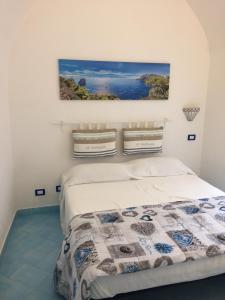 a bedroom with a bed with a picture on the wall at La Casa di Paola in Nerano
