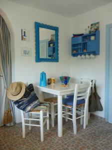 mesa de comedor blanca con sillas y espejo en Lemon Tree Cottage, en Finikounta