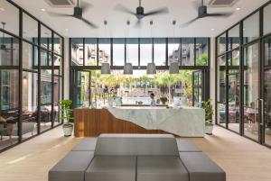 a lobby with a reception desk and windows at Saturdays Residence by Brown Starling in Rawai Beach