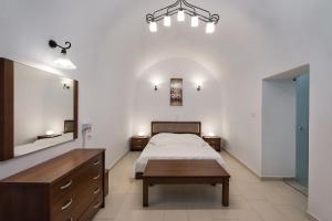 um quarto com uma cama, uma mesa e um espelho em Unique Leta em Fira