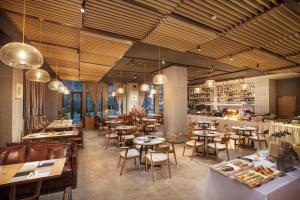 a restaurant with tables and chairs and a bar at Somerset Yangtze River Chongqing in Chongqing