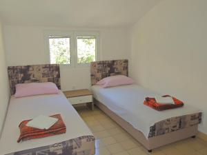 a bedroom with two beds and a window at Guest House Jelena in Budva