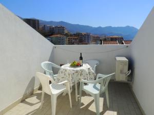 a table and chairs on a balcony with a bottle of wine at Guest House Jelena in Budva