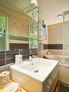 a bathroom with a white sink and a tub at Studio Apartment Green Wall in Zagreb