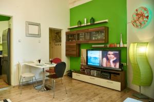 a living room with a television and a table with chairs at Studio Apartment Green Wall in Zagreb