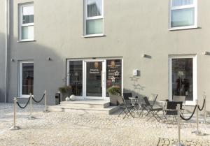 a building with chairs and a table in front of it at Aparthotel Othello in Dingolfing