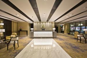 um átrio de um hotel com uma recepção e cadeiras em Ambassador Transit Hotel - Terminal 3 em Singapura