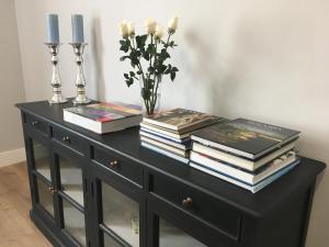 ein schwarzer Schrank mit Büchern und eine Vase mit Kerzen in der Unterkunft Beautifulilla in Madrid