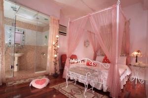 冬山鄉的住宿－情定珍珠民宿，粉红色的卧室设有天蓬床和淋浴