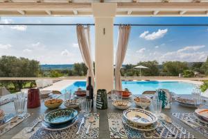 a dining table with a view of a pool at Casa Murredda by BarbarHouse in Ceglie Messapica
