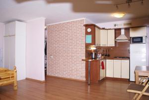 a kitchen and living room with a brick wall at Studio Na Pervom Etazhe in Moscow