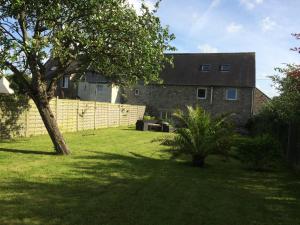 a house with a fence and a tree in a yard at Entre Terre et Mer in Réville +8 photos
