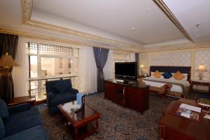 メディナにあるAl Rawda Royal Innのベッドとテレビが備わるホテルルームです。