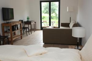 salon z łóżkiem, kanapą i telewizorem w obiekcie Lindenhof Gästehaus & Hofcafe w mieście Kranenburg