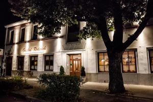 ein weißes Gebäude mit einem Baum davor in der Unterkunft Gasthof Roderich Hotel in Langenzersdorf