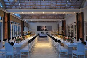 a long banquet hall with long tables and blue chairs at B&B Kasteel Maurick in Vught