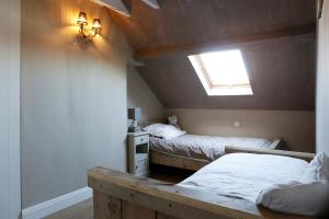 a attic room with two beds and a window at Les Maisons de la Mer in Ostend