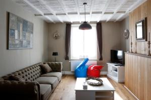 ein Wohnzimmer mit einem Sofa und einem TV in der Unterkunft Les Maisons de la Mer in Ostende