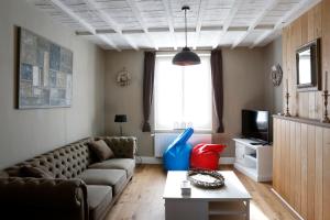 - un salon avec un canapé et une télévision dans l'établissement Les Maisons de la Mer, à Ostende
