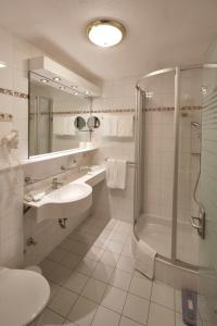 a bathroom with a shower and a sink and a tub at VAYA Lechtal in Elbigenalp