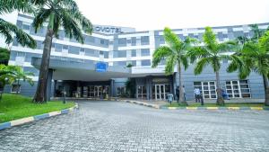 a large building with palm trees in front of it at Novotel Port Harcourt in Port Harcourt