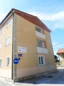 a yellow building with a blue sign in front of it at Villa Doris YourCroatiaHoliday in Premantura
