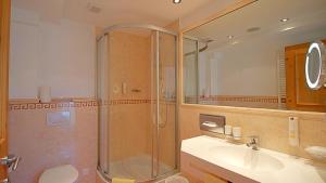 a bathroom with a shower and a sink and a toilet at Samnaunerhof Vital-Hotel in Samnaun +30 photos