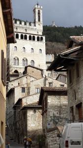 a large white building with a clock tower on a street at A Casa di Cristina in Gubbio