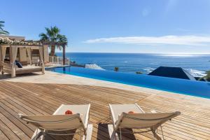 eine Terrasse mit 2 Stühlen und einem Pool in der Unterkunft Compass House Boutique Hotel - Adults Only in Kapstadt