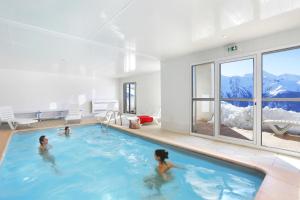 two women in a swimming pool in a house at Résidence Néméa Royal Peyragudes in Germ