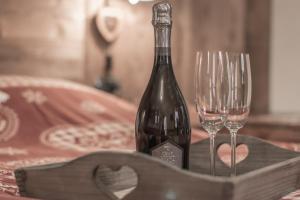 a bottle of wine and two wine glasses on a table at Lo Ni di Candolle in Gignod