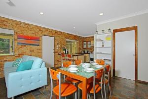 a kitchen and dining room with a table and chairs at Chappies in Woollamia