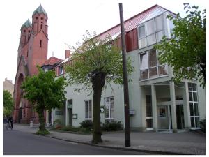 un edificio en una calle con una iglesia en Akzent Parkhotel Trebbin, en Trebbin