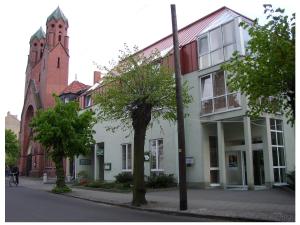 a building on a street with a church at Akzent Parkhotel Trebbin in Trebbin