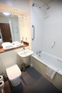 a bathroom with a sink and a toilet and a tub at Talardy, St Asaph by Marston’s Inns in St Asaph