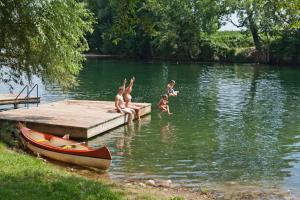 a group of children playing in the water at a dock at Holiday resort & camping Bela krajina - river Kolpa in Metlika