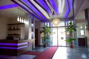 een lobby met paarse verlichting en potplanten bij Hotel Blue Moon in Ulcinj