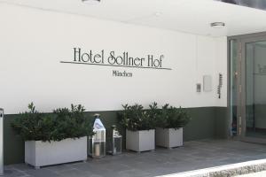 um sinal de porco hoteleiro na lateral de um edifício com plantas em Hotel Sollner Hof em Munique