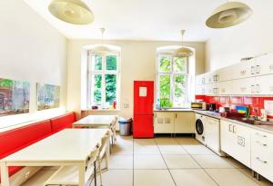 eine Küche mit einem Tisch und einem roten Kühlschrank in der Unterkunft Grampa's Hostel in Breslau