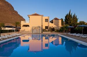 a villa with a swimming pool in front of a house at Apartamentos Baja Del Secreto in Valle Gran Rey