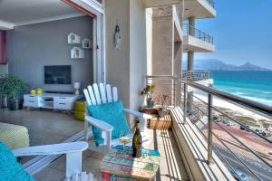 a room with a balcony with a view of the ocean at Portico 802 in Bloubergstrand